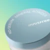 Tapa del bote de Innisfree No-Sebum Mineral Powder en primer plano sobre fondo claro