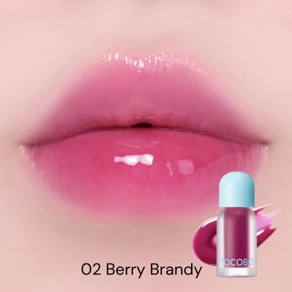 Modelo usando Tocobo Juicy Berry Plumping Lip Oil tono Berry Brandy 02 en los labios.