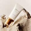 Madagascar Centella Air-Fit Suncream Light – Fotografía artística Protector solar Madagascar Centella Air-Fit Suncream Light de SKIN1004 colocado sobre rocas en una composición artística