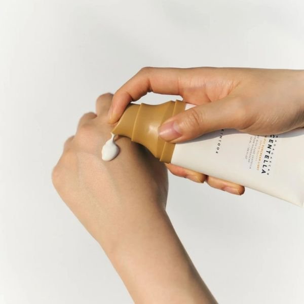 Textura del Madagascar Centella Air-Fit Suncream Light Envase del protector solar Madagascar Centella Air-Fit Suncream Light de SKIN1004 dispensando el producto sobre una mano para mostrar la textura